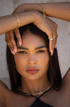 Woman wearing gold jewellery with a neutral background
