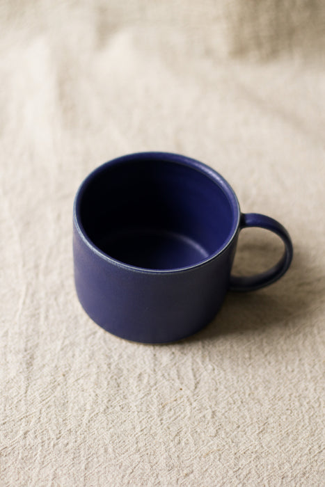 Blue mug on a beige textured surface