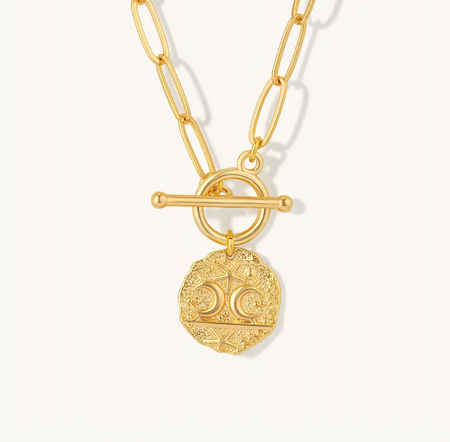 Gold necklace with a detailed pendant on a white background