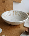 White ceramic bowl with textured design on a wooden surface