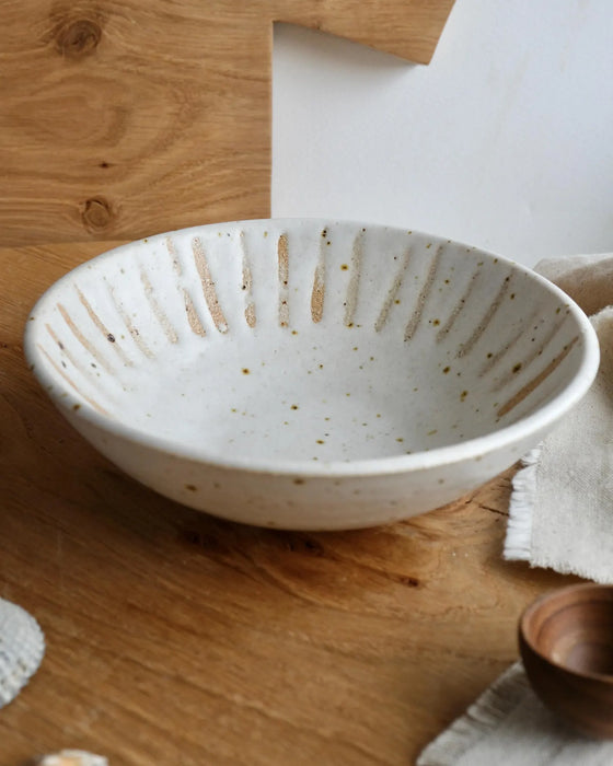 White ceramic bowl with textured design on a wooden surface