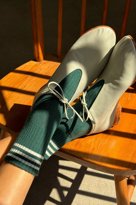 Sage shoes with green socks on a wooden chair