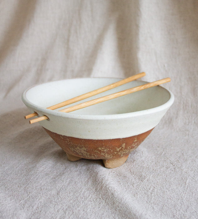 Stoneware and cream glazed ramen bowl with chopsticks, against a neutral inen backdrop