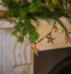 Decorative Christmas garland with star-shaped ornaments on a fireplace mantel.