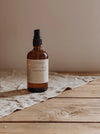 Bottle of moka natural sleep calming mist on a wooden surface with a beige background