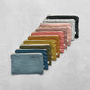 Row of colourful linn pouches on a light grey background