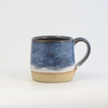 Ceramic mug with blue and beige design on a white background