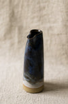 Ceramic blue jug with textured surface on a beige fabric background