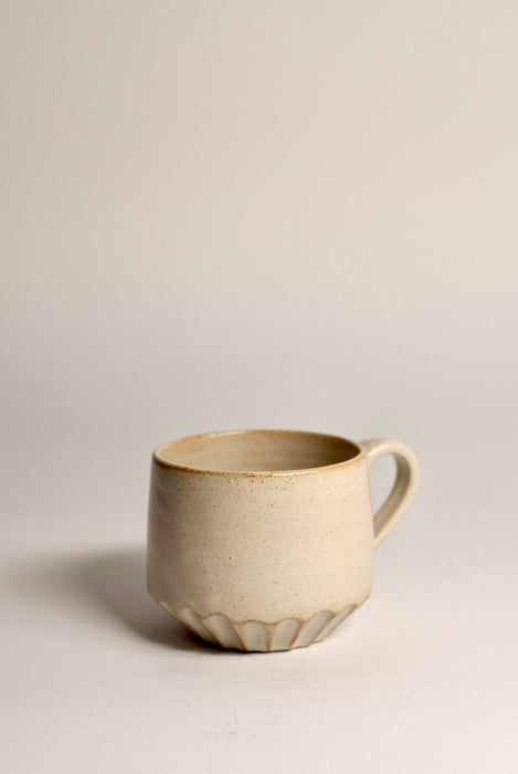Beige ceramic mug on a light grey background