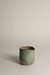 Green ceramic jug on a light grey background