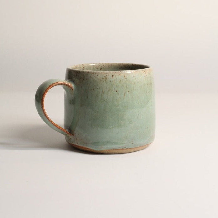 Green ceramic mug on a light grey background