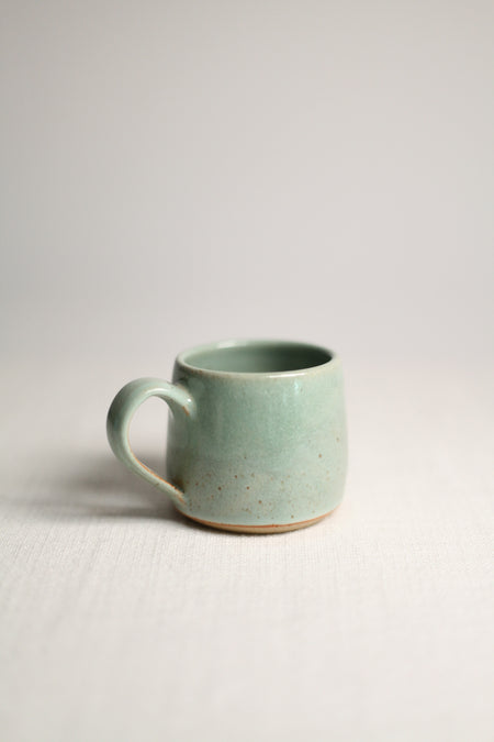 Green ceramic mug on a white background