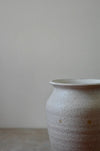Cream stoneware vase on a grey surface and background