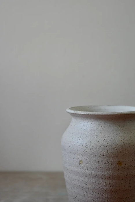 Cream stoneware vase on a grey surface and background