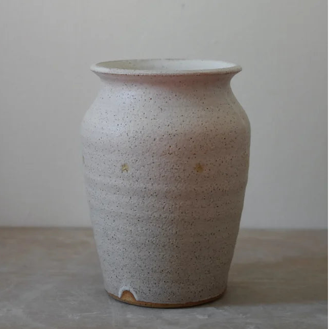 Cream stoneware vase on a grey surface and background