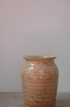 Ceramic vase with speckled brown and beige pattern on a plain grey background