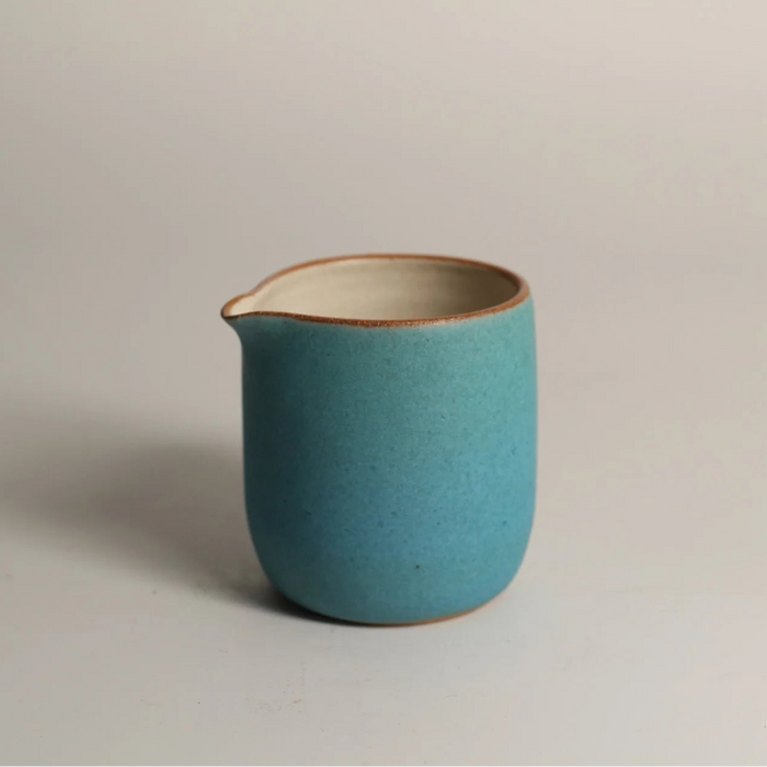 Turquoise ceramic jug on a light grey background