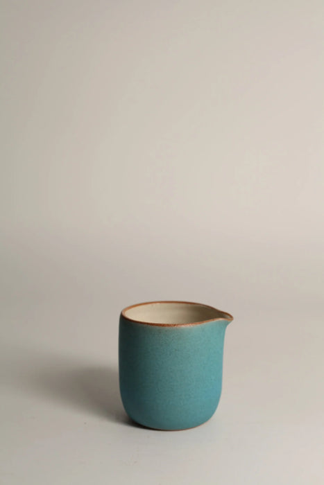 Turquoise ceramic jug with on a grey background