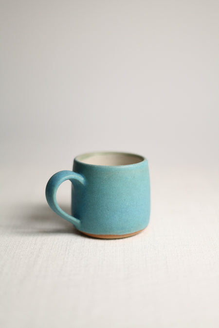 Blue ceramic mug on a light grey background