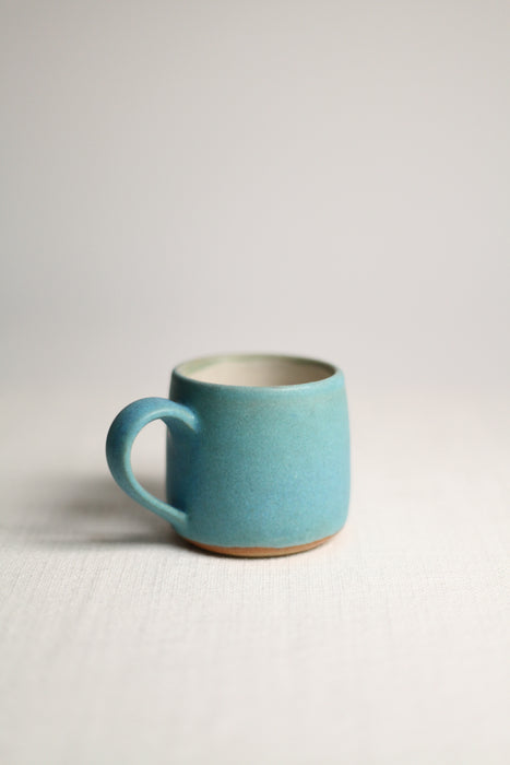 Blue ceramic mug on a light grey background