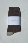Brown wool socks with a white label on a light grey background