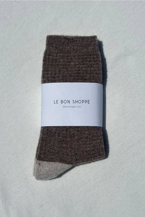 Brown wool socks with a white label on a light grey background