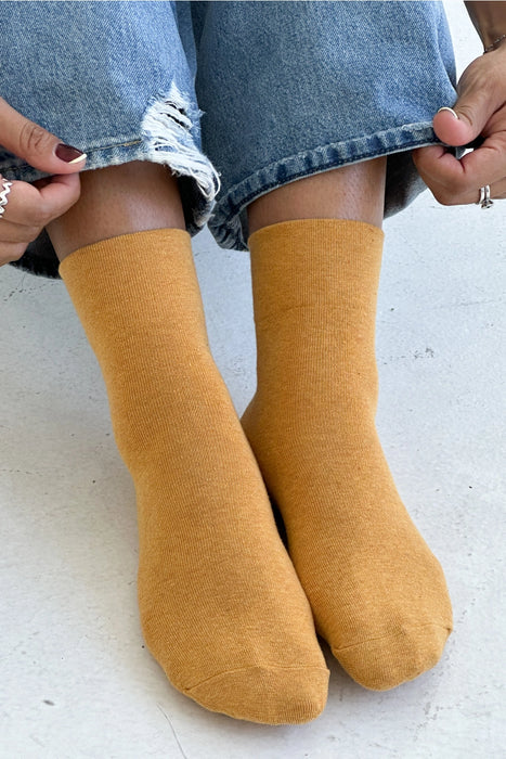 person wearing yellow socks and blue jeans 