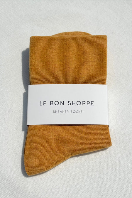 pair of yellow socks in a white pack on a white surface