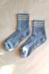 A pair of blue ankle socks with white stripes, displayed on a flat surface.