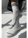 White socks with navy stripes on a light grey background