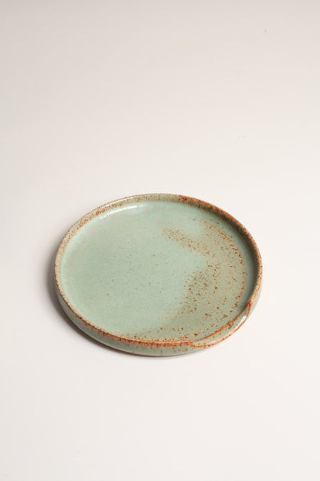 A ceramic spoon rest with a satin green glaze, displayed on a white background.