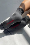 Gray socks with red text on a light gray surface