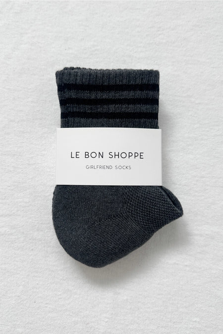 Pair of dark grey socks with a white label on a white background